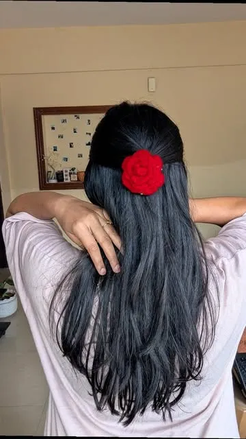 Red crochet rose clip in long dark hair